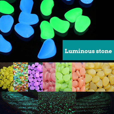 Resplandor colorido en los guijarros oscuros del jardín para la piedra luminosa de la decoración del jardín