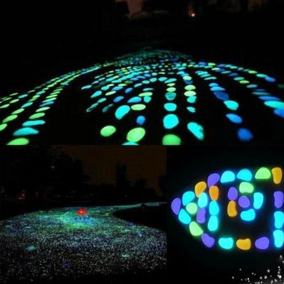 Resplandor colorido en los guijarros oscuros del jardín para la piedra luminosa de la decoración del jardín